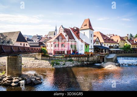 Pont Lazebnický menant aux cafés et restaurants sur la rive Vitava dans la vieille ville de Cesky Krumlov. Banque D'Images
