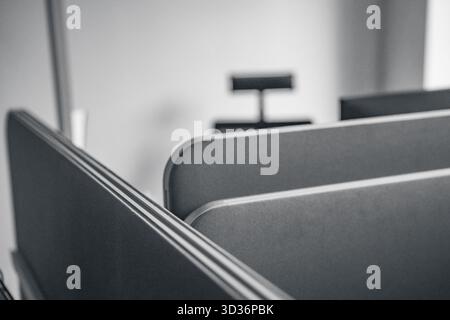 Une photographie minimaliste en noir et blanc met en valeur un espace de bureau moderne avec des chaises élégantes et une lampe élégante, créant un sophistiqué et profes Banque D'Images