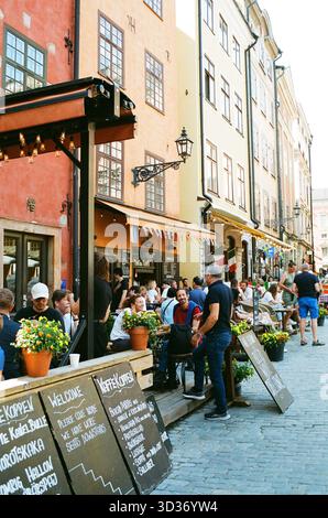 Les clients apprécient de dîner en plein air à Stockholm par une journée d'été ensoleillée, en s'imprégnant de l'atmosphère vibrante de la ville et du chaud soleil scandinave Banque D'Images