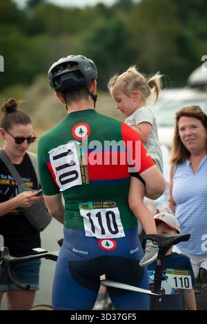 Green Mountain Stage Race, Canaan Motor Club, New Hampshire, États-Unis. 1er septembre 2025. Compétiteur professionnel de critères de vélo debout au-dessus de son vélo avec sa famille à la fin de la course au Canaan Motor Club dans le New Hampshire le dernier jour de la Green Mountain Stage Race de quatre jours. Le 25e événement annuel parrainé par le Green Mountain Bicycle Club a lieu pendant la fête du travail aux États-Unis. Plus de 500 coureurs de vélo de route professionnels et amateurs masculins et féminins ont participé à l'une des plus grandes courses par étapes en Amérique du Nord. Banque D'Images