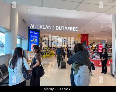 Magasin Dutyfree d'Auckland avec les voyageurs parcourant une large gamme de produits et une promotion Alipay visible à l'aéroport d'Auckland, Nouvelle-Zélande. Banque D'Images