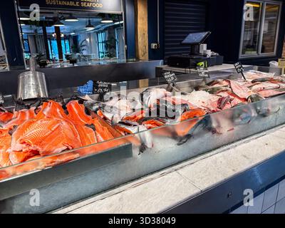 Marché aux poissons d'Auckland. Filets de saumon frais, poissons entiers et autres fruits de mer exposés sur glace dans un étal de vente au détail Banque D'Images