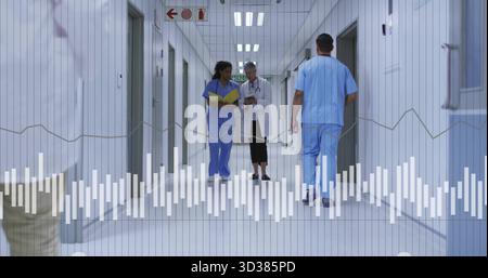 Équipe médicale ambulante discutant des données des patients dans le couloir de l'hôpital, avec dossier jaune et tablette Banque D'Images
