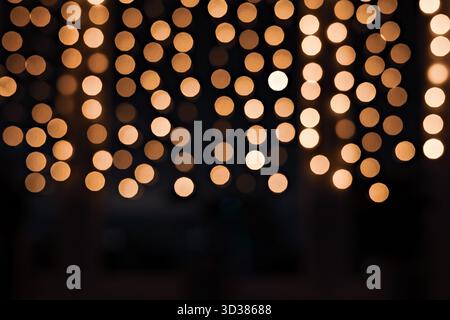 Rangées verticales de lumières Bokeh chaudes sur fond sombre Banque D'Images