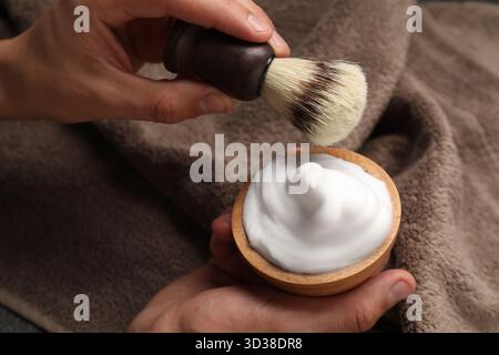 Brosse de maintien de barbier avec mousse à raser et serviette, gros plan Banque D'Images
