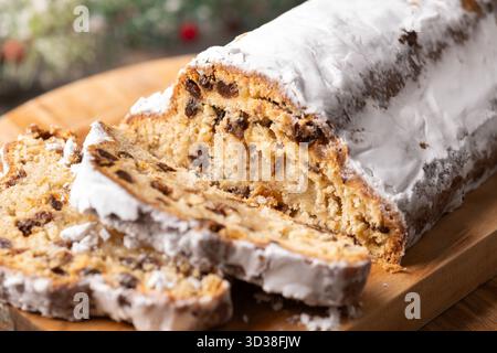 Stollen de Noël traditionnel avec raisins secs et sucre en poudre sur une table en bois Banque D'Images