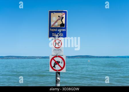 Panneaux d'avertissement au lac Balaton, Hongrie, interdisant la plongée, les chiens et la pêche sur une plage publique par une journée ensoleillée d'été. Banque D'Images