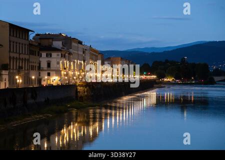 Lumières de la ville se reflétant sur le fleuve Arno au crépuscule à Florence, Italie Banque D'Images