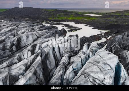 Vue aérienne de la langue du glacier Solheimajokull et des bandes de frêne en Islande Banque D'Images