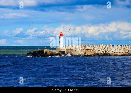 Phare au bout de la jetée nord de Ventspils, Lettonie – brise-lames en béton sur la côte de la mer Baltique Banque D'Images