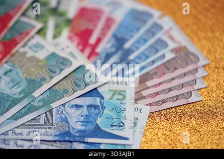 Pakistan roupies billets de banque sur fond jaune doré. Les factures d'argent pakistanaises actuelles sont sur la table en gros montant. Le concept d'affaires et d'investissement au Pakistan Banque D'Images