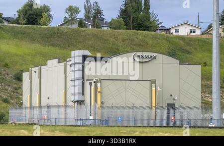 Calgary, Alberta, Canada. 12 juillet 2025. Une sous-station de service public ENMAX est sécurisée et moderne contre une colline herbeuse, mélangeant l'infrastructure avec Banque D'Images