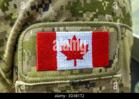 Calgary, Alberta, Canada. 12 juillet 2025. Un gros plan d'un écusson du drapeau canadien sur un uniforme de camouflage militaire, symbolisant le service national, l'identité, Banque D'Images