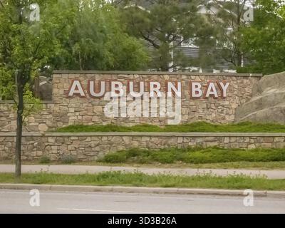 Calgary, Alberta, Canada. 8 juin 2025. Un panneau en pierre robuste affiche fièrement AUBURN BAY, niché au milieu d'une végétation luxuriante, marquant l'entrée de cette photo Banque D'Images