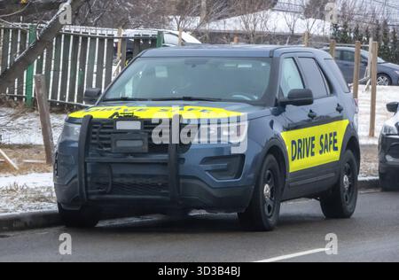 Calgary, Alberta, Canada. 13 mars 2025. Un VUS de police avec autocollants de SÉCURITÉ ROUTIÈRE à l'avant et sur le côté, stationné dans une rue enneigée, mettant l'accent sur la sécurité routière Banque D'Images