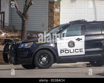 Calgary, Alberta, Canada. 12 mars 2025. Calgary police SUV garé sur une rue résidentielle, vue partielle sur la maison, journée ensoleillée Banque D'Images