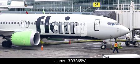 Calgary, Alberta, Canada. 4 mars 2025. Un Boeing 737 de Flair Airlines est stationné à une porte d'aéroport, son fuselage blanc affichant bien en évidence le flair L. Banque D'Images