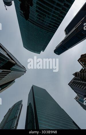 Vue sur les gratte-ciels vitreux percer le ciel silencieux, une danse moderne d'acier et de lumière atteignant les cieux, Singapour, Singapour. Banque D'Images