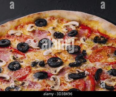 Nourriture, Pizza à la tomate, olives, champignons, jambon et fromage Banque D'Images