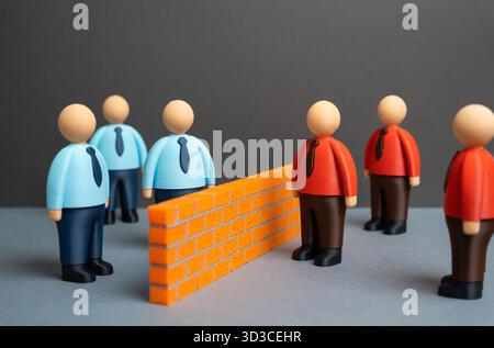 Un mur de briques sépare deux camps idéologiques de travailleurs de bureau. Deux équipes ou départements commerciaux opposés. Compétition, désaccord d'équipe ou workpla Banque D'Images