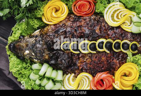 Nourriture, carpe cuite au four avec des légumes gros plan dans un plat de cuisson sur la table Banque D'Images