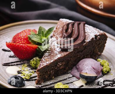 Nourriture, gâteau Brownie avec une boule de glace à la vanille et des fraises Banque D'Images