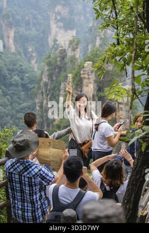 Zhangjiajie, Chine - août 2019 : touriste chinoise posant pour des photos sur le point de vue de la chaîne de montagnes Tianzi, parc naturel des montagnes Avatar Banque D'Images