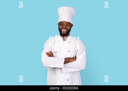 Portrait de beau jeune Chef noir en uniforme debout avec les bras pliés Banque D'Images