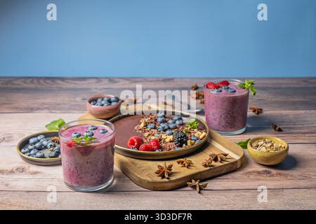 Des céréales se déversent du récipient, dispersant astucieusement autour de la base du verre à smoothie Banque D'Images