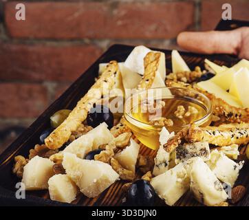 Nourriture, assiette de fromage avec miel, raisins et noix Banque D'Images