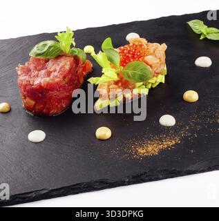 Nourriture, saumon et tartare de bœuf sur tableau noir Banque D'Images