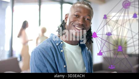 Homme souriant avec des tresses portant une chemise en denim dans le salon, équipe parlant par les fenêtres, superposition violette Banque D'Images