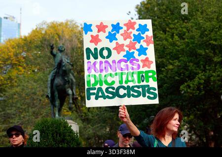 Une femme tient une pancarte "pas de rois, dictateur, fascistes" lors d'une manifestation contre l'administration Trump, le 18 octobre 2025, New York Banque D'Images