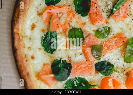 Pizza avec saumon et épinards dans une boîte Banque D'Images