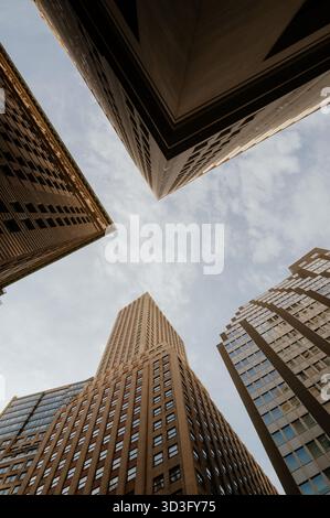 D'en bas, une vue spectaculaire des gratte-ciels de New York atteignant le ciel. La perspective offre un aperçu unique des merveilles architecturales de la ville Banque D'Images