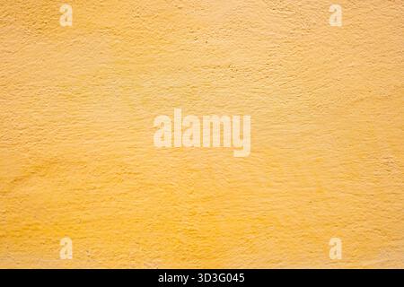Un mur texturé jaune vif avec des détails de surface subtils, offrant une finition riche et mate. Les motifs complexes fournissent une profondeur visuelle, adapté pour b Banque D'Images