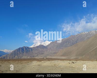 'Majestueuse chaîne de montagnes de l'Himalaya avec des sommets enneigés et un terrain désertique aride sous un ciel bleu profond à Mustang, Népal' Banque D'Images