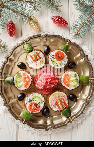 Sandwichs boules de Noël avec fromage à la crème et légumes gros plan dans une assiette sur la table. Vue de dessus verticale Banque D'Images