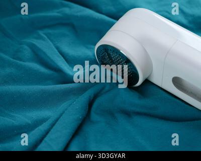 Détachant portable couché sur un vêtement bleu. Banque D'Images