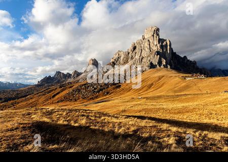 Montagnes enneigées spectaculaires entourant le passage emblématique du Passo Giau dans les Dolomites, en Italie, avec des lariches dorées vibrantes d'automne. Banque D'Images