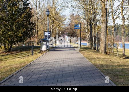 Sentier pavé bordé d'arbres le long du front de mer avec bancs et lampadaires Banque D'Images