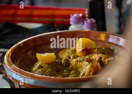 Tajine de poulet marocain traditionnel avec olives et citrons salés, focus sélectif. Tajine de poulet, plat traditionnel marocain de morceaux de poulet. Banque D'Images