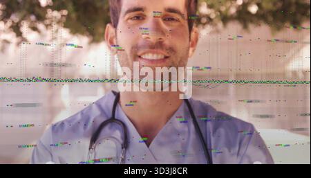 Professionnel masculin souriant portant des gommages bleus debout dans la cour, avec stéthoscope autour du cou Banque D'Images