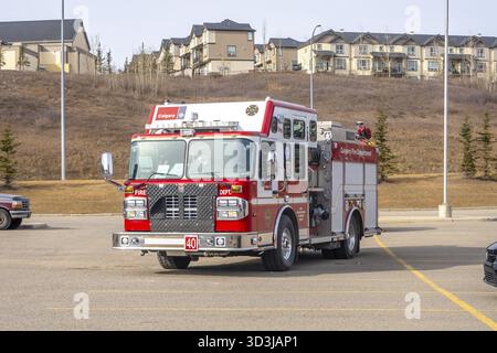 Calgary, Alberta, Canada. 23 mars 2025. Une photo frontale d'un camion rouge et blanc du service d'incendie de Calgary garé dans un terrain asphalté, avec résidence Banque D'Images