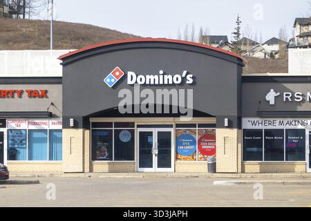 Calgary, Alberta, Canada. 23 mars 2025. Une photo au niveau de la rue d'un magasin Domino's Pizza dans un centre commercial, avec son logo et sa devanture avec promoti Banque D'Images