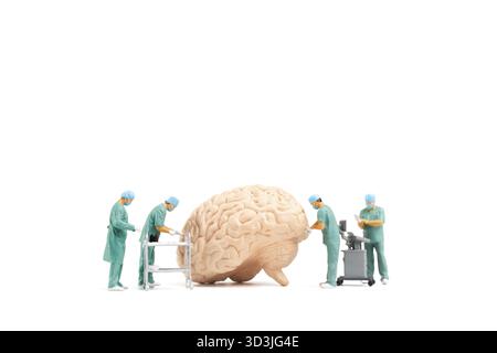 Les personnes miniatures, le médecin et l'équipe médicale d'infirmière effectuent une opération chirurgicale à la salle d'urgence sur fond blanc Banque D'Images