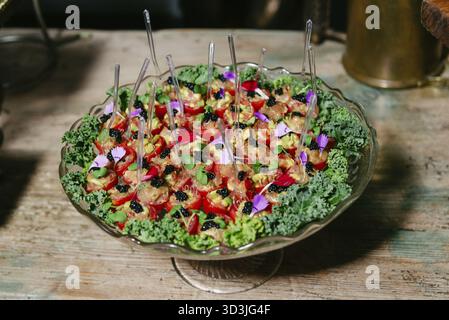 Nourriture, Un plateau de hors-d'œuvre magnifiquement arrangé avec tartare de thon dans des tomates cerises, garni de caviar, de microlégumes verts et de fleurs comestibles Banque D'Images