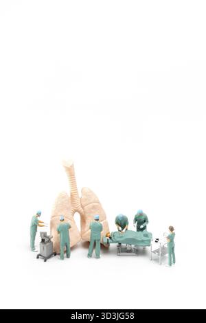Les personnes miniatures, le médecin et l'équipe médicale d'infirmière effectuent une opération chirurgicale à la salle d'urgence sur fond blanc Banque D'Images