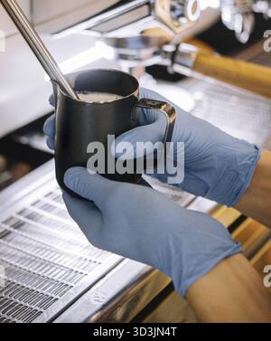 Nourriture, Barista préparant de la mousse de lait dans le gobelet en métal Banque D'Images