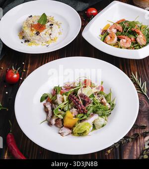 Nourriture, différentes salades dans des assiettes blanches sur une table en bois Banque D'Images